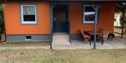 Monteurwohnung - Oschatz - Vorderansicht des Gästehauses /Gästebungalow mit überdachter Terrasse, Sitzmöglichkeiten, Raucherinsel und Grillfläche. - Pension Lausa