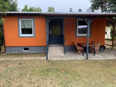 Monteurzimmer: Vorderansicht des Gästehauses /Gästebungalow mit überdachter Terrasse, Sitzmöglichkeiten, Raucherinsel und Grillfläche. - Pension Lausa