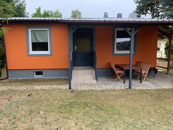 Monteurzimmer: Vorderansicht des Gästehauses /Gästebungalow mit überdachter Terrasse, Sitzmöglichkeiten, Raucherinsel und Grillfläche. - Pension Lausa