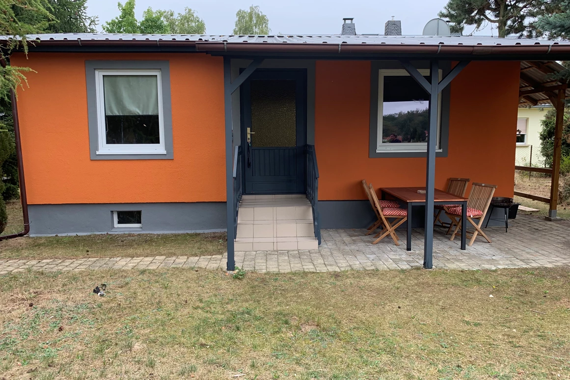 Monteurzimmer: Vorderansicht des Gästehauses /Gästebungalow mit überdachter Terrasse, Sitzmöglichkeiten, Raucherinsel und Grillfläche. - Pension Lausa