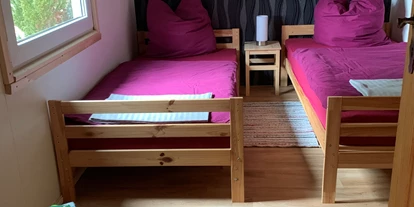 Monteurwohnung - Oschatz - Erstes Schlafzimmer mit zwei Einzelbetten, Nachttisch mit Nachttischlampe, Kleiderschrank, Stuhl, Fernseher und Verdunklungsrollo. - Pension Lausa