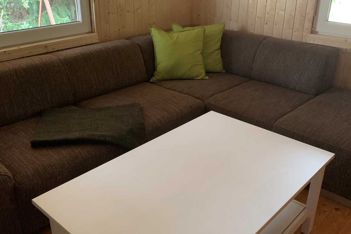 Monteurzimmer: Wohn- und Esszimmer mit offener Küche.
Couch, Couchtisch mit Fernseher. - Pension Lausa
