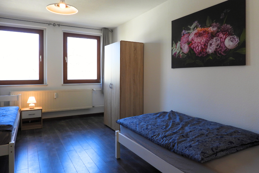 Monteurwohnung - TV - Elbeland - Gemütliches Schlafzimmer mit zwei Einzelbetten sowie zwei Schränken. - flex living -  Monteurwohnungen in Chemnitz