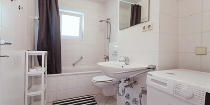 Monteurwohnung - Kaffeemaschine - Bielefeld - helles Badezimmer mit Waschamschine - flex living -  Monteurwohnungen in Bielefeld