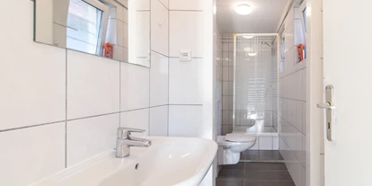 Monteurwohnung - Muggensturm Gaggenau - Funktionales Badezimmer mit Dusche, WC und Waschmaschine.
 - flex living -  Monteurwohnungen in Karlsruhe
