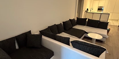 Monteurwohnung - Muggensturm Gaggenau - Modernes Wohnzimmer mit großem Sofa & 60-Zoll-TV – ideal zum Entspannen nach der Arbeit - Top Wohnung in Karlsruhe Zentrum