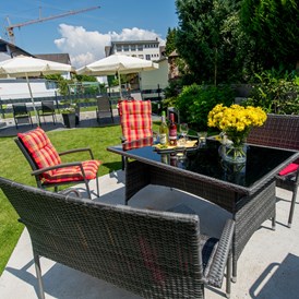 Monteurzimmer: Garten und Terrasse mit Tisch und Stühlen für alle Gäste - Apartmenthaus & Ferienwohnungen Horster