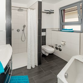 Monteurzimmer: Moderne, frische Duschbäder mit Handtüchern. - Apartmenthaus & Ferienwohnungen Horster