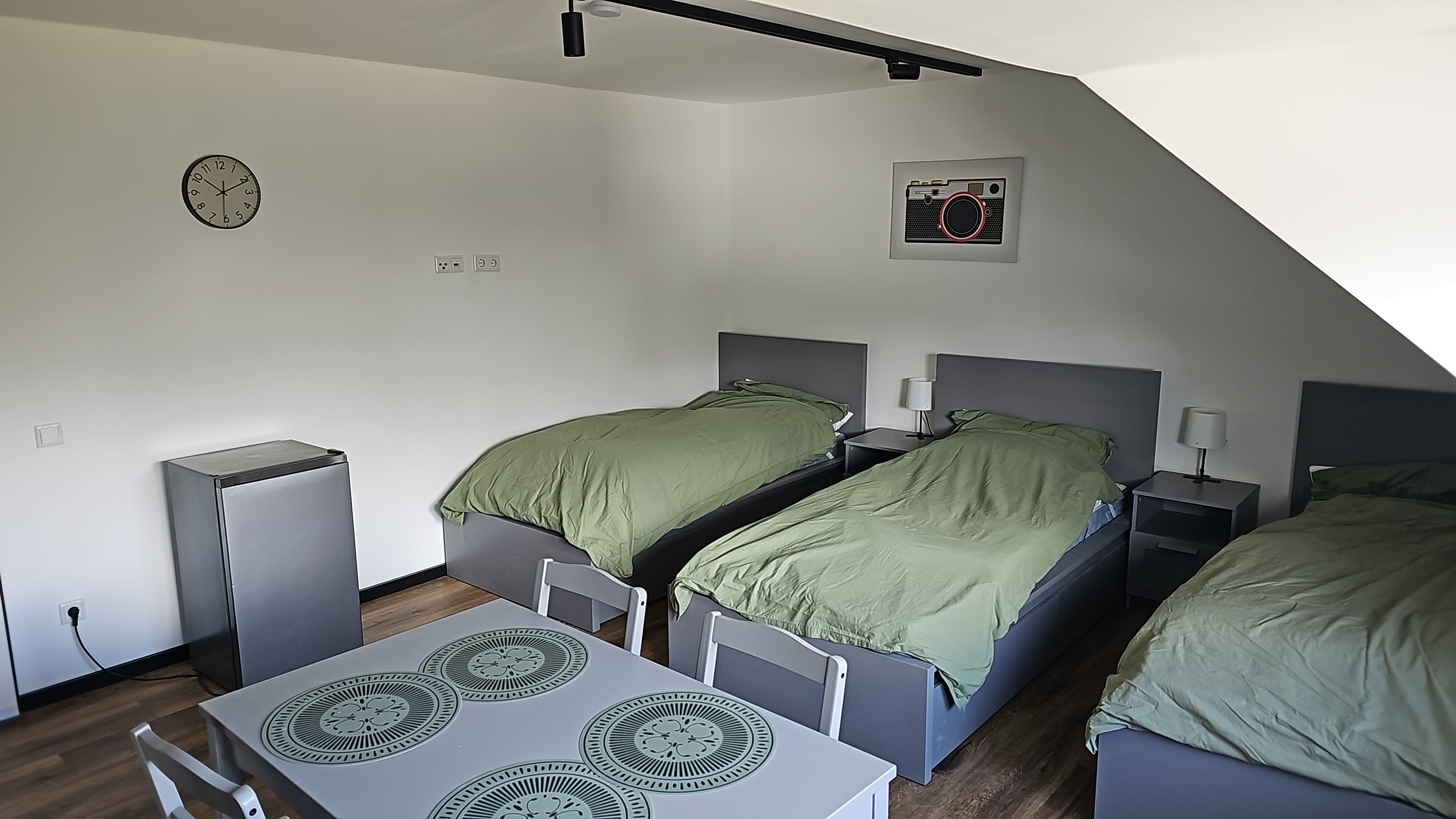 Monteurwohnung - PLZ 45881 (Deutschland) - Zimmer 2 – Dreibettzimmer
Das Dreibettzimmer ist ideal für kleine Teams: Drei Einzelbetten mit je eigenem Nachttisch und 
Lampe bieten ausreichend Platz zum Schlafen. TV, WLAN, Kleiderschränke sowie ein Esstisch mit 
Stühlen und ein Mini-Kühlschrank gehören zur Ausstattung. - Möblierte Monteurwohnung zur Miete