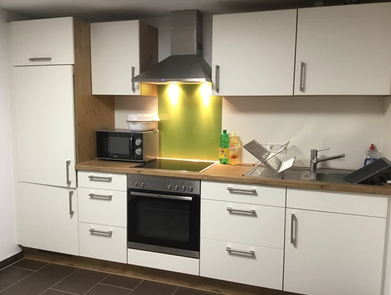 Monteurzimmer: Küche mit Kühlschrank, Backofen, Cerankochfeld und Mikrowelle. - Pfeils Ferienwohnung