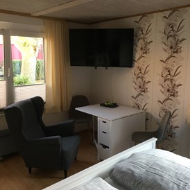 Monteurzimmer: Fernseher mit Sitzbereich im eigentlichen Zimmer - Apartment Wernigerode