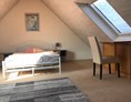 Monteurzimmer: Sitzbereich mit Doppelbett der Monteurunterkunft Engel in Hohberg. - ENGEL 