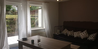 Monteurwohnung - Lauffen am Neckar - Essgelegenheit und Blick auf die Terrasse sowie eine weitere Schlafgelegenheit der Zwei-Zimmer-Wohnung - Schlehenweg