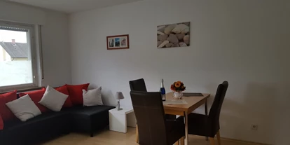 Monteurwohnung - Kehl - Wohn-Schlafzimmer mit Essbereich, Fernseher und Doppelbett. Nichtraucherzimmer - Ferienwohnung Bruckenfeld Rheinau-Linx
