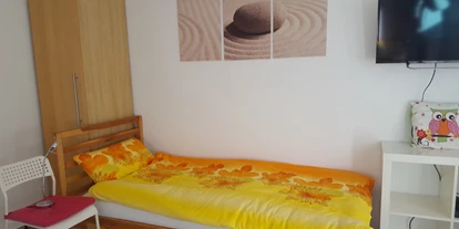 Monteurwohnung - Kehl - Schlafzimmer 2 mit 2 Einzelbetten, Fernseher, Schrank, Zugang zum Balkon. Nichtraucherzimmer - Ferienwohnung Bruckenfeld Rheinau-Linx