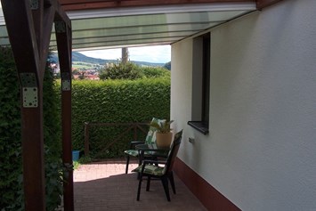 Monteurzimmer: Die überdachte Sitzecke im Garten (Raucherinsel) - Ferienwohnung Wanderurlaub in Schmalkalden