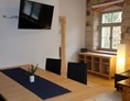 Monteurzimmer: Wohnzimmerbereich mit Sofa, TV, Esstisch - Hammergut Neidberg in Bielatal - 20 Betten