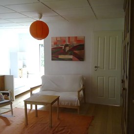 Monteurzimmer: Wohnzimmer mit Doppelbett und Tür zum Schlafzimmer - Ferienhaus Joey