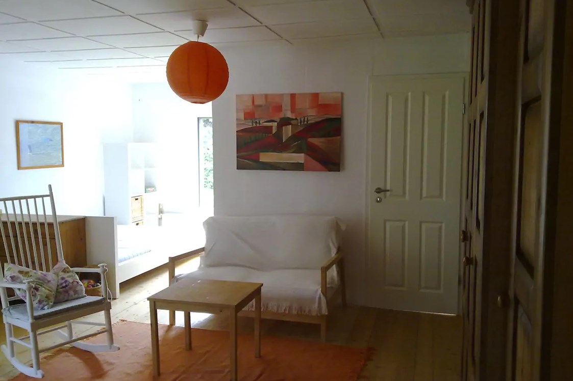 Monteurzimmer: Wohnzimmer mit Doppelbett und Tür zum Schlafzimmer - Ferienhaus Joey