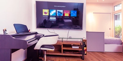 Monteurwohnung - PLZ 2482 (Österreich) - Wohnzimmer - Smart-TV Netflix-YouTube 75-Zoll-Fernseher - Einzelbett - Senator-Flats Paulus