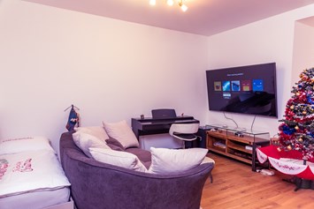 Monteurzimmer: Wohnzimmer - Smart-TV Netflix-YouTube 75-Zoll-Fernseher - Senator-Flats Paulus