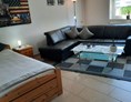 Monteurzimmer: Wohnzimmer mit Ledercouch  TV und zusätzlichen Einzelbett  - Ferienwohnung Marschall Schweinfurt Hassfurt
