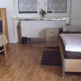 Monteurzimmer: Einzelbett mit Nachttisch - Gästehaus Müller