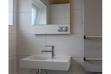 Monteurzimmer: Waschtisch im Bad, beleuchteter Spiegel - Monty