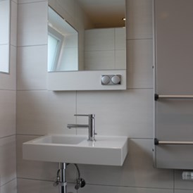 Monteurzimmer: Waschtisch im Bad, beleuchteter Spiegel - Monty
