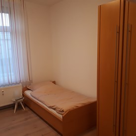 Monteurzimmer: Bett Schlafzimmer Wohnbereich - Schloß Holte Bahnhof