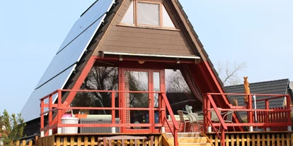 Monteurwohnung - Bettwäsche: Bettwäsche gegen Gebühr - Deutschland - Das Bild zeigt unser Haus II. Haus I steht direkt nebenan. Die Häuser haben je eine Wohnfläche von 60 m2. Aufgeteilt in einen schönen Wohnbereich mit Couch und Essecke, Voll ausgestatteter Küche, Bad mit Dusch/WC und je zwei Schlafräumen mit je zwei Einzelbetten bleiben keine Wünsche offen. Beide Häuser verfügen über eine Terrasse mit Blick auf die Kanäle.  - Ferienhäuser Familie Hecht