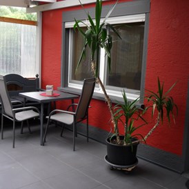 Monteurzimmer: Sitzplatz unter der überdachten Terrasse - Wohnung Idefix 1 SZ: 2 Einzelbetten + Bettcouch