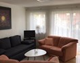 Monteurzimmer: Wohnzimmer mit Schlafsofa und Zugang zum Balkon - Ferienwohnung Creutzig